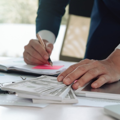 Business appraisal services being conducted with financial documents and cash on the table in a corporate office setting Business appraisal services being conducted