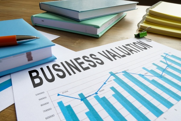 Business valuation report and analysis with charts and educational materials on desk Business valuation report and analysis