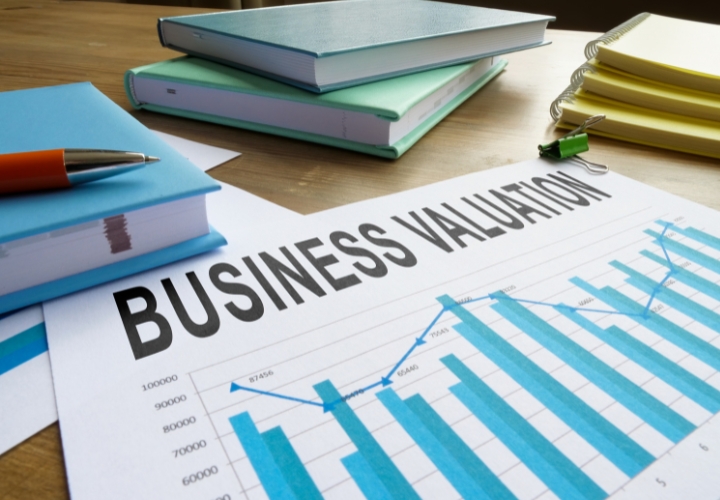 Business valuation services for legal and tax compliance with charts and documents on a desk Valuation services for legal and tax compliance